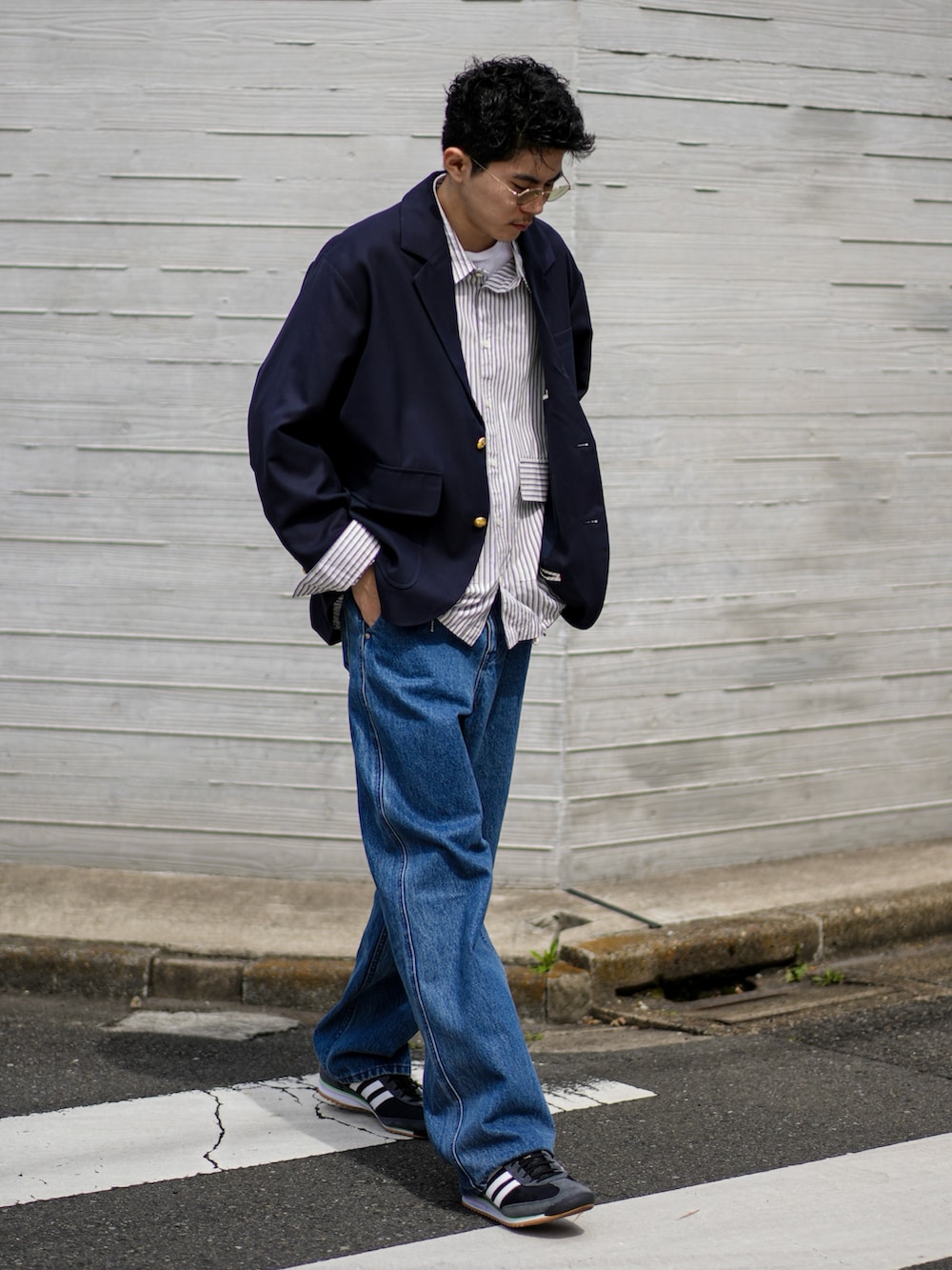 ブルー系のテーラードジャケット、ブルー系のデニムパンツ、ブラック系のスニーカーを着用したメンズの春コーディネートの4枚目の写真