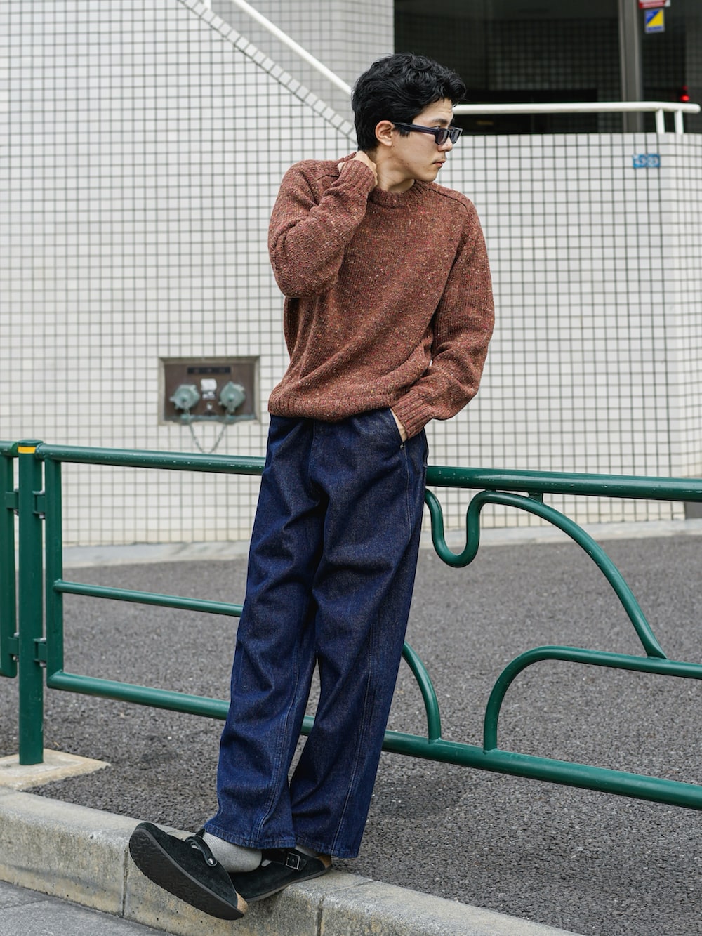 ブラウン系のニット/セーター、ブルー系のデニムパンツ、ブラック系のサンダルを着用したメンズの秋コーディネートの2枚目の写真