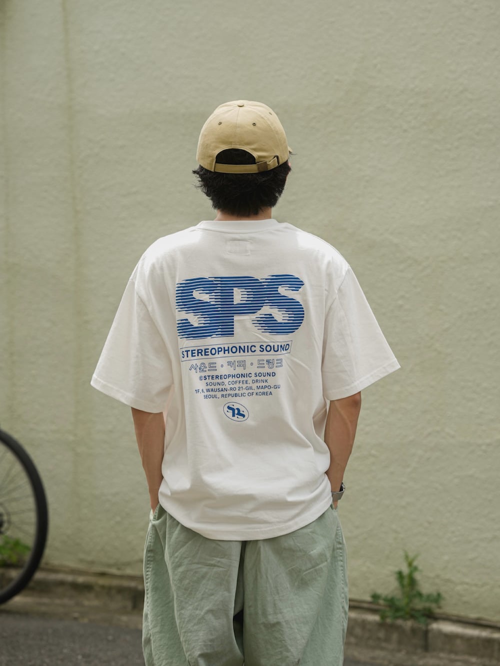 グリーン系のパンツ、ホワイト系のTシャツ/カットソー、ブルー系のスニーカーを着用したメンズの夏コーディネートの5枚目の写真