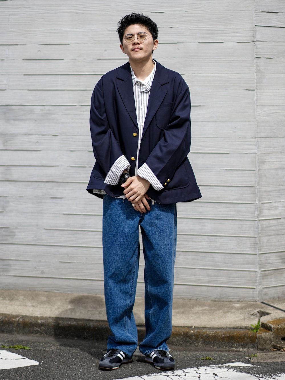 ブルー系のテーラードジャケット、ブルー系のデニムパンツ、ブラック系のスニーカーを着用したメンズの春コーディネートの2枚目の写真