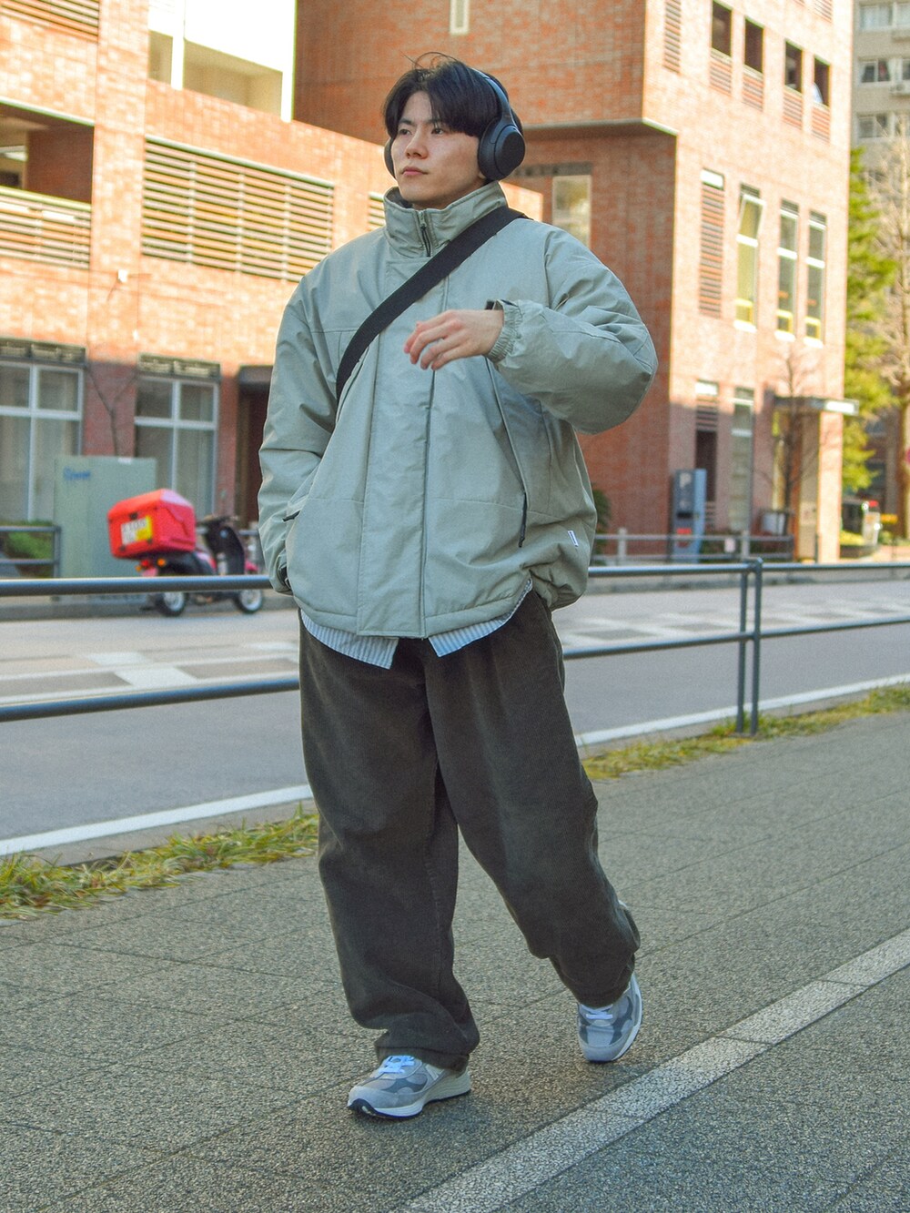 グレー系のスニーカー、グリーン系のショルダーバッグを着用したメンズの冬コーディネートの2枚目の写真