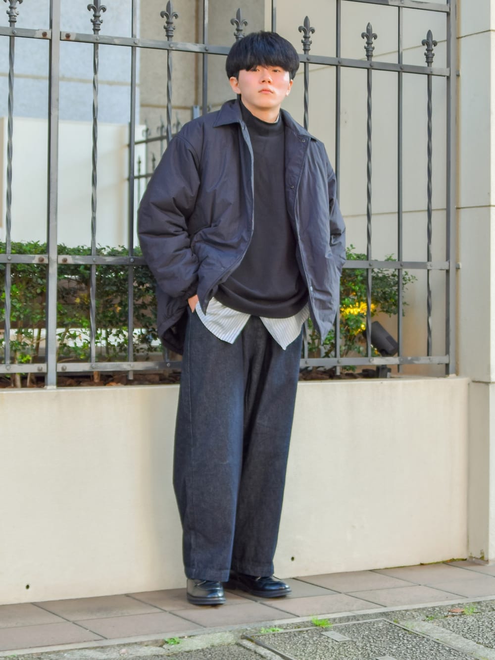 ブラック系のブルゾン、ブラック系のデニムパンツ、ブラック系のドレスシューズを着用したメンズの冬コーディネートの2枚目の写真