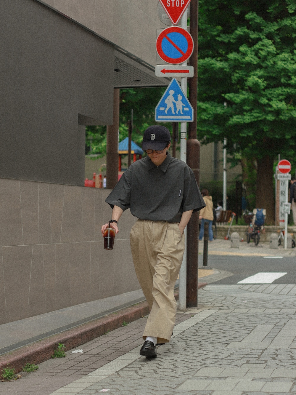 グレー系のその他トップス、ベージュ系のチノパンツ、ブラック系のローファーを着用したメンズの夏コーディネートの2枚目の写真