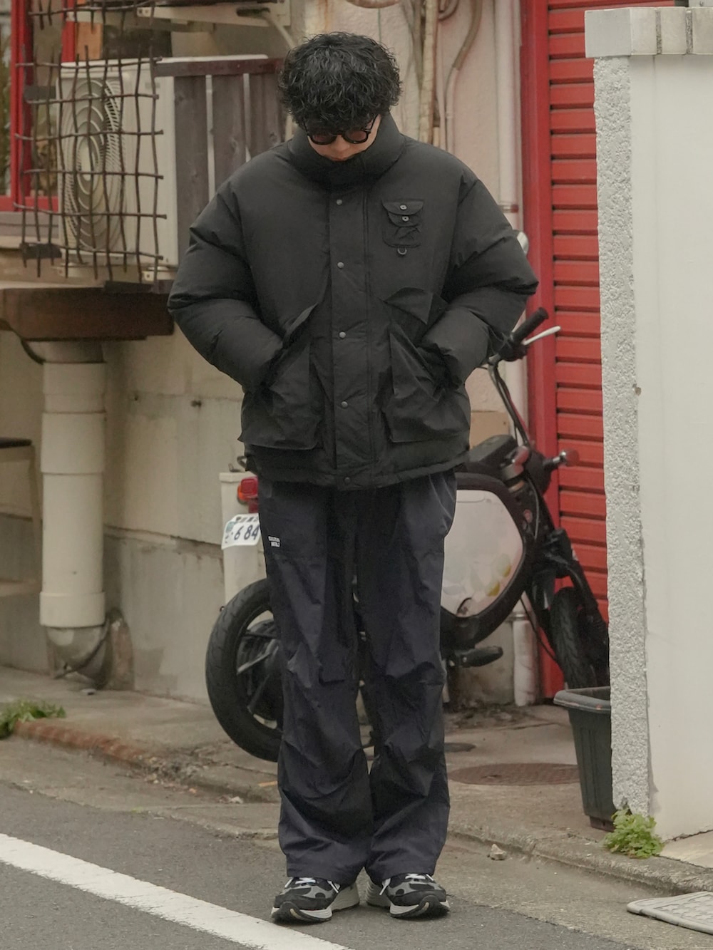 ブラック系のダウンジャケット/コート、ブラック系のパンツ、ブラック系のスニーカーを着用したメンズの冬コーディネートの2枚目の写真