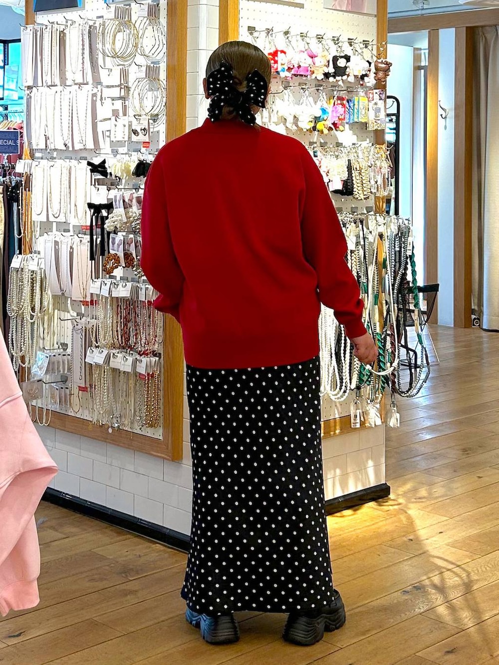 ブラック系のスカート、ブラック系のローファー、レッド系のニット/セーターを着用したレディースの春コーディネートの3枚目の写真