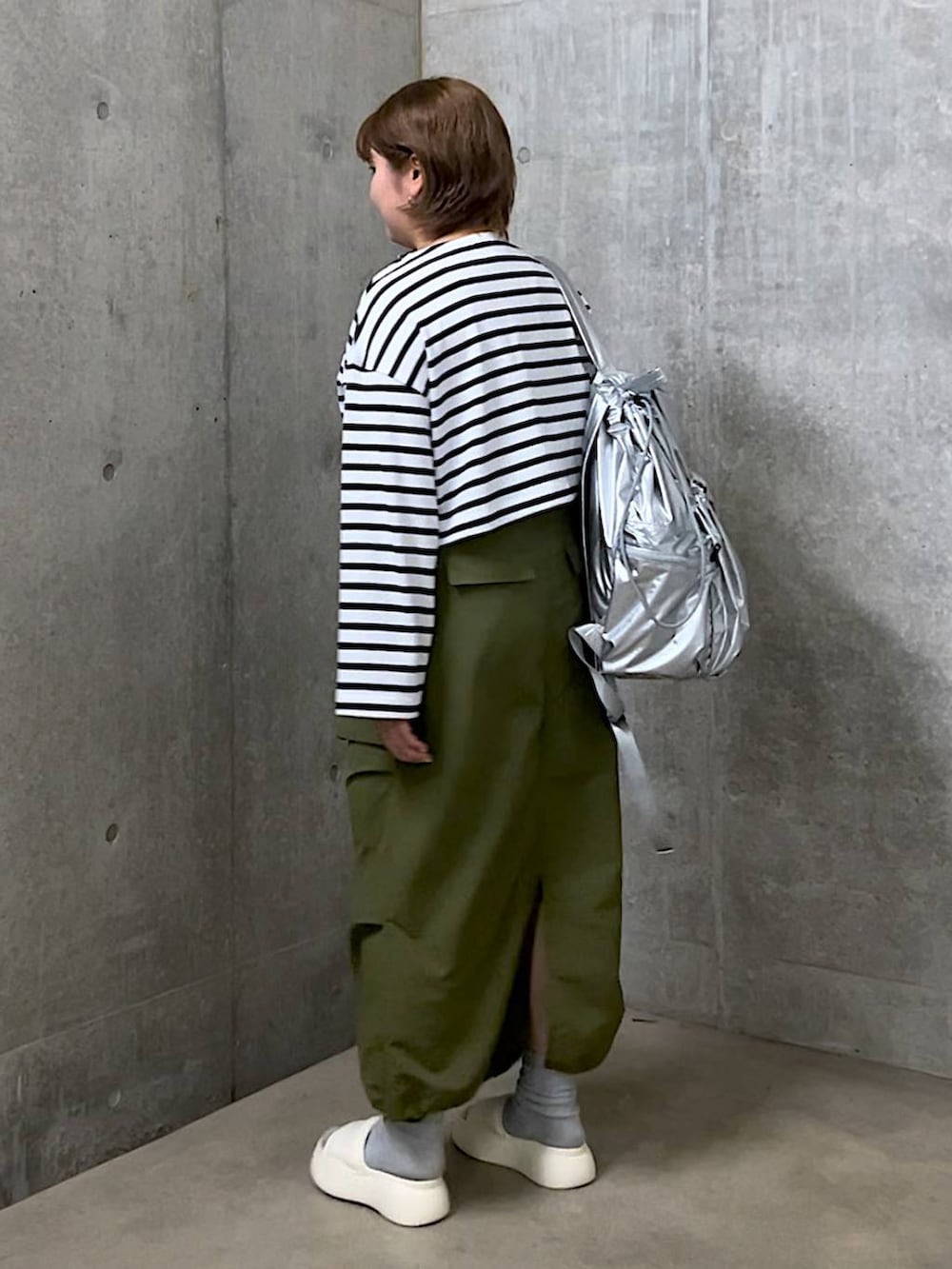 ホワイト系のサンダル、ブルー系のTシャツ/カットソー、シルバー系のバックパック/リュックを着用したレディースの春コーディネートの3枚目の写真