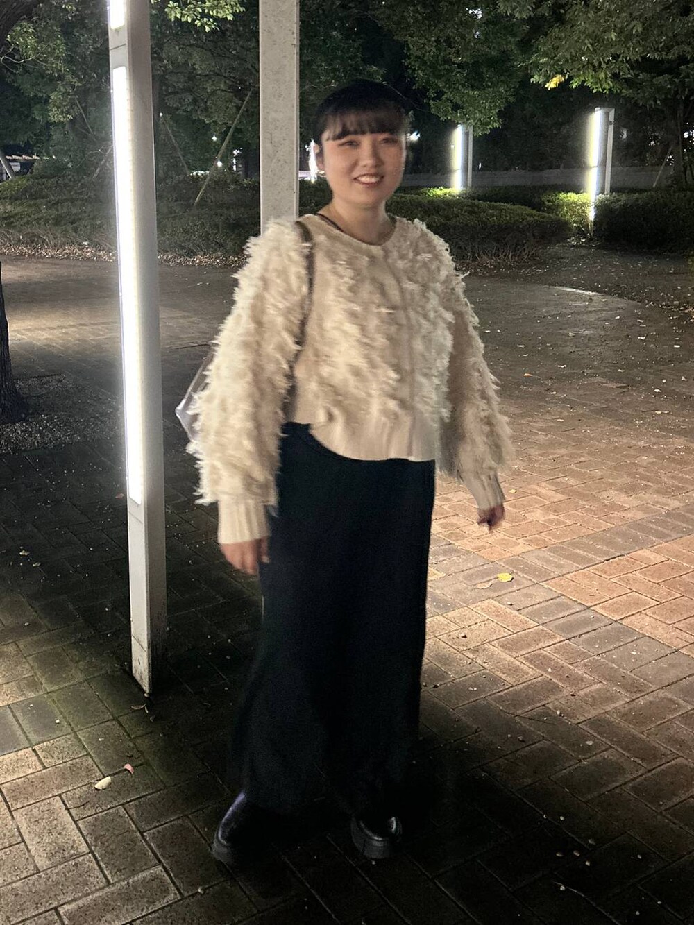 ブラック系のスラックス、ホワイト系のカーディガン/ボレロ、ブラック系のカチューシャを着用したレディースの秋コーディネートの2枚目の写真