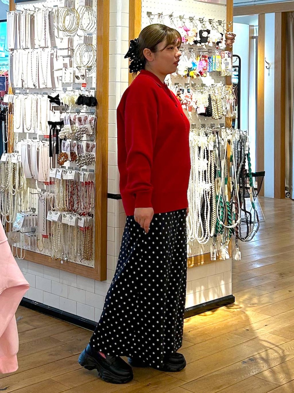 ブラック系のスカート、ブラック系のローファー、レッド系のニット/セーターを着用したレディースの春コーディネートの2枚目の写真