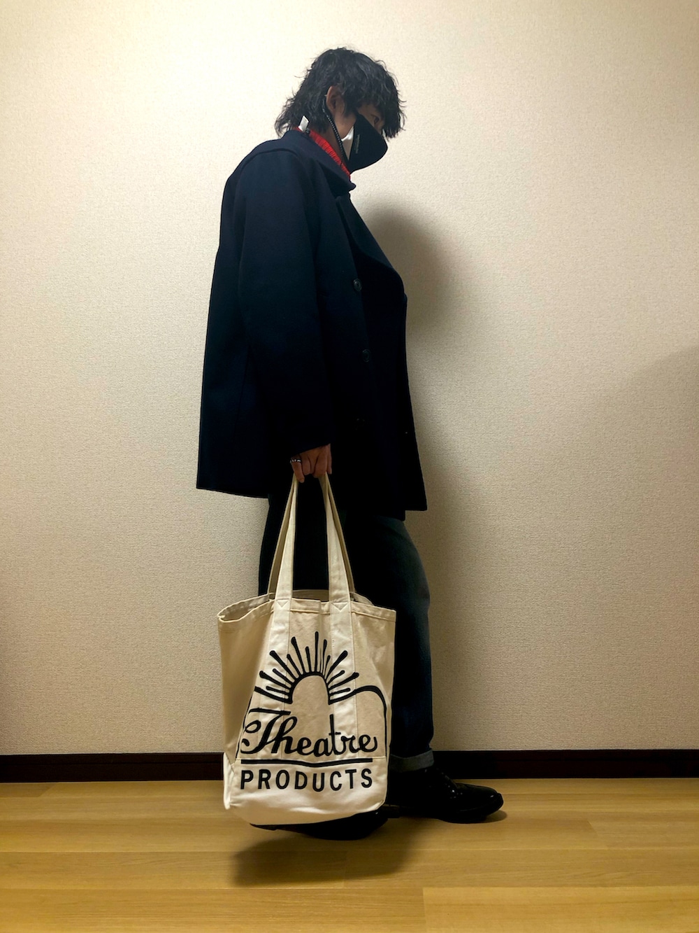 ホワイト系のトートバッグ、ブラック系のスニーカー、ブルー系のデニムパンツを着用したメンズの冬コーディネートの3枚目の写真