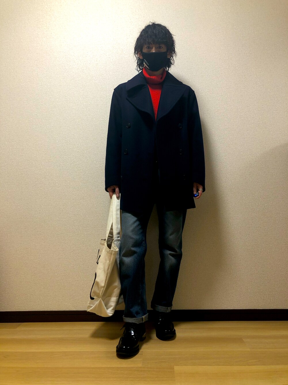 ホワイト系のトートバッグ、ブラック系のスニーカー、ブルー系のデニムパンツを着用したメンズの冬コーディネートの4枚目の写真