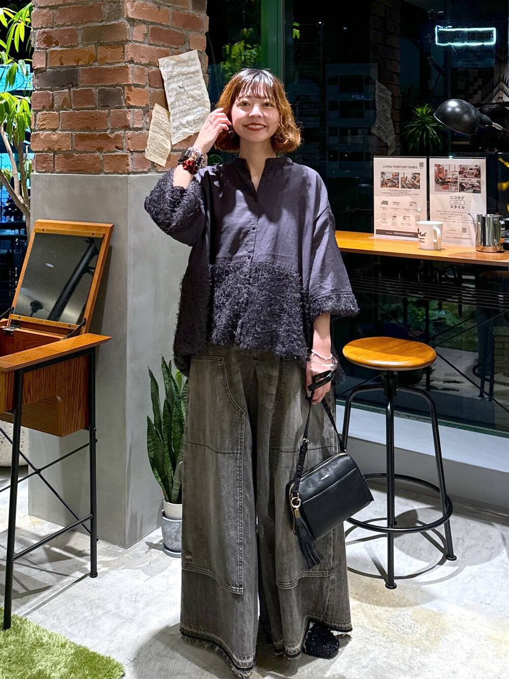 ブラック系のバレエシューズ、ブラック系のショルダーバッグ、ブラウン系のデニムパンツを着用したレディースの秋コーディネートの7枚目の写真