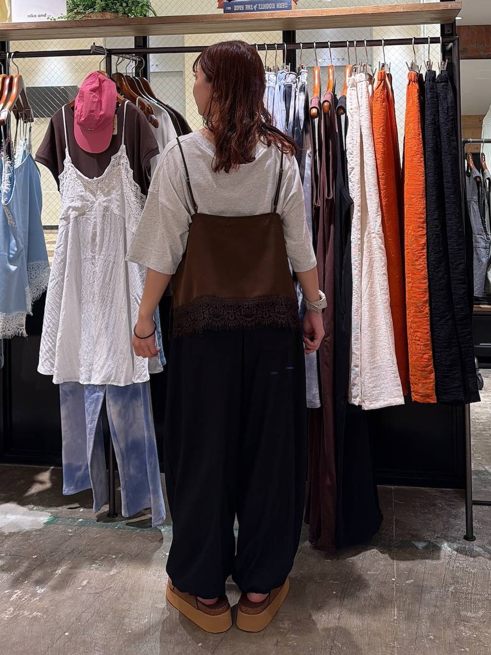 ブラウン系のサンダル、ブラック系のその他パンツ、ベージュ系のTシャツ/カットソーを着用したレディースの夏コーディネートの5枚目の写真
