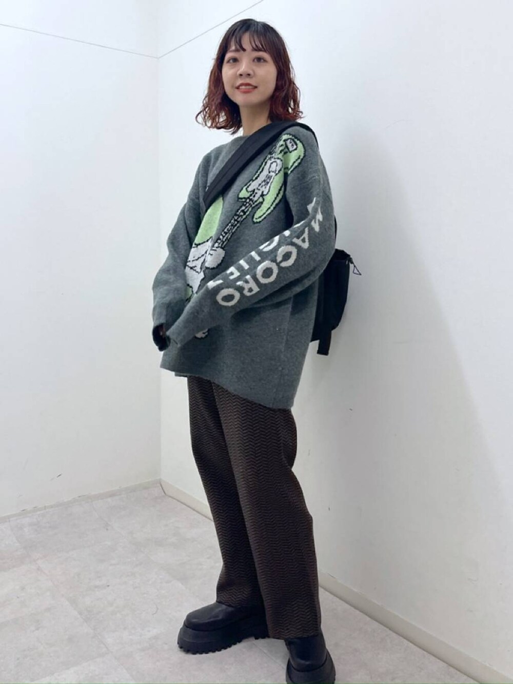 ブルー系のその他パンツ、ブラック系のブーツ、ブラック系のショルダーバッグを着用したレディースの冬コーディネートの3枚目の写真