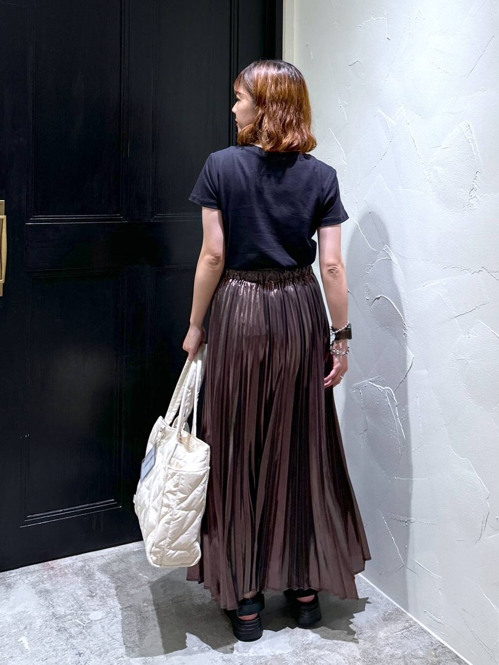 ブラック系のサンダル、ホワイト系のトートバッグ、ベージュ系のスカートを着用したレディースの夏コーディネートの3枚目の写真