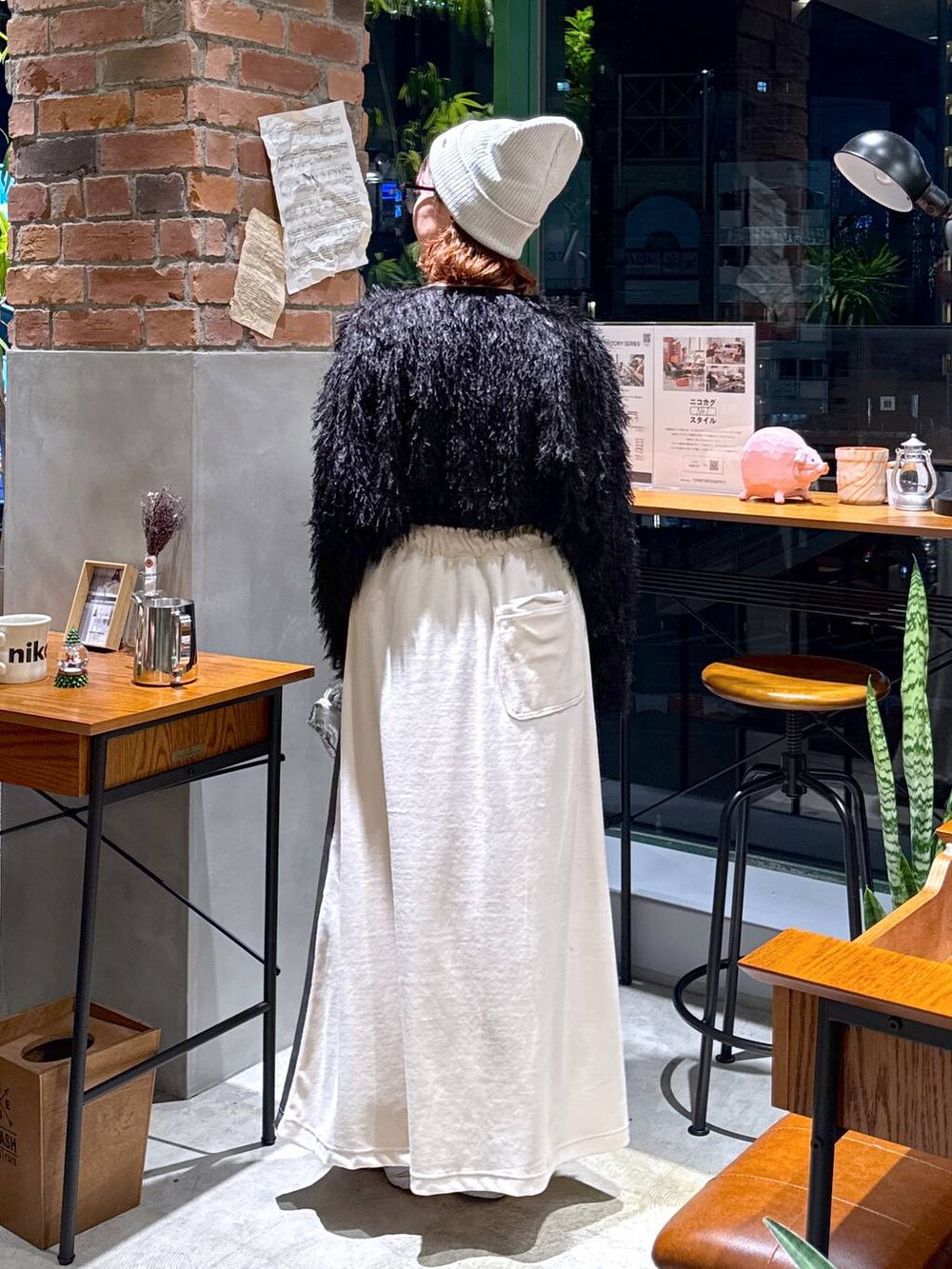 シルバー系のショルダーバッグ、ブラック系のその他トップス、ベージュ系のスカートを着用したレディースの冬コーディネートの4枚目の写真