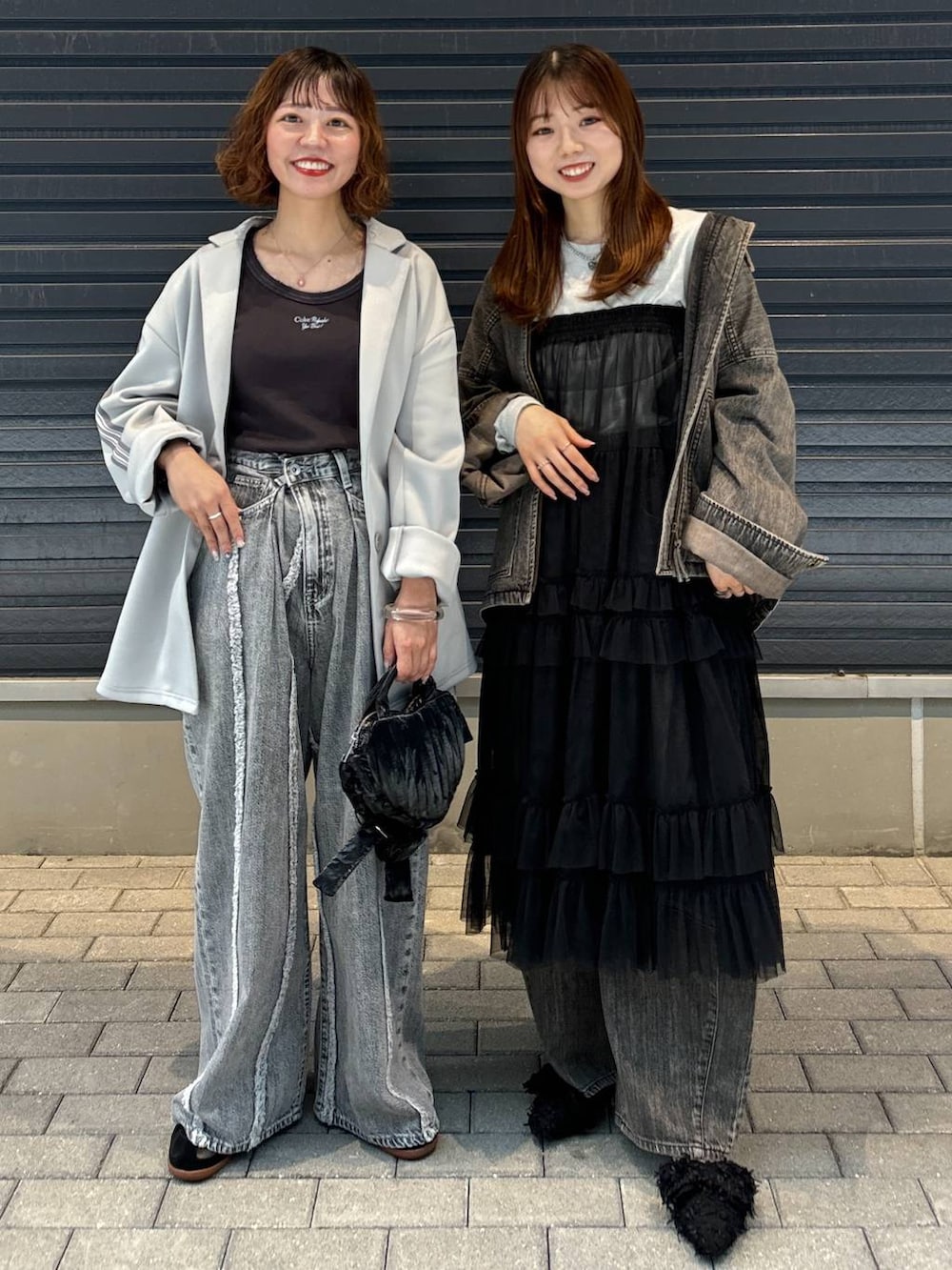 グレー系のTシャツ/カットソー、ブラック系のスカート、グレー系のデニムパンツを着用したレディースの秋コーディネートの4枚目の写真