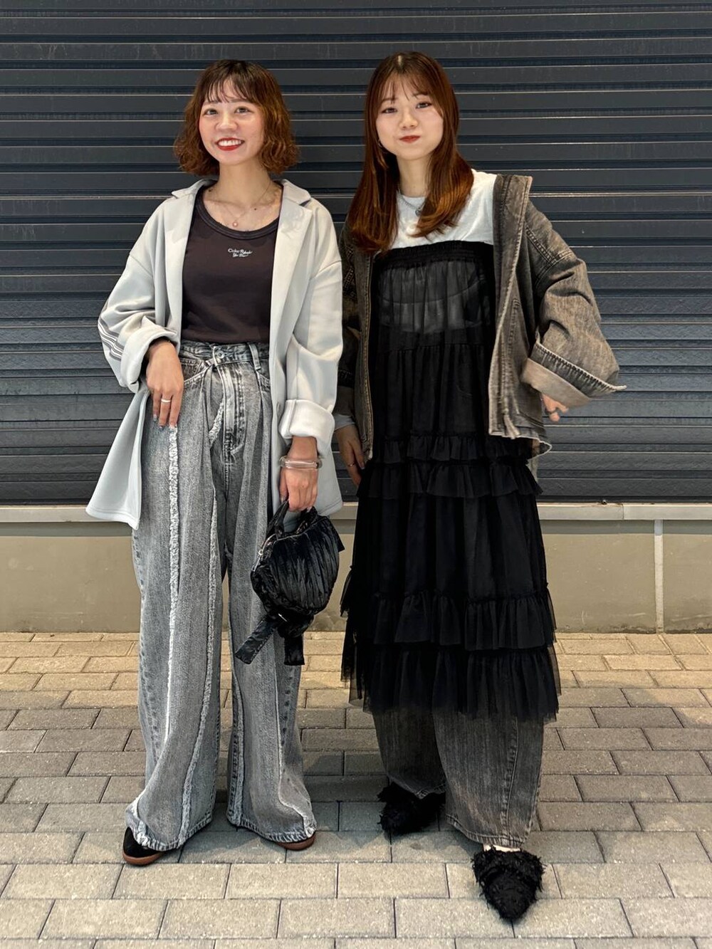 グレー系のTシャツ/カットソー、ブラック系のスカート、グレー系のデニムパンツを着用したレディースの秋コーディネートの5枚目の写真