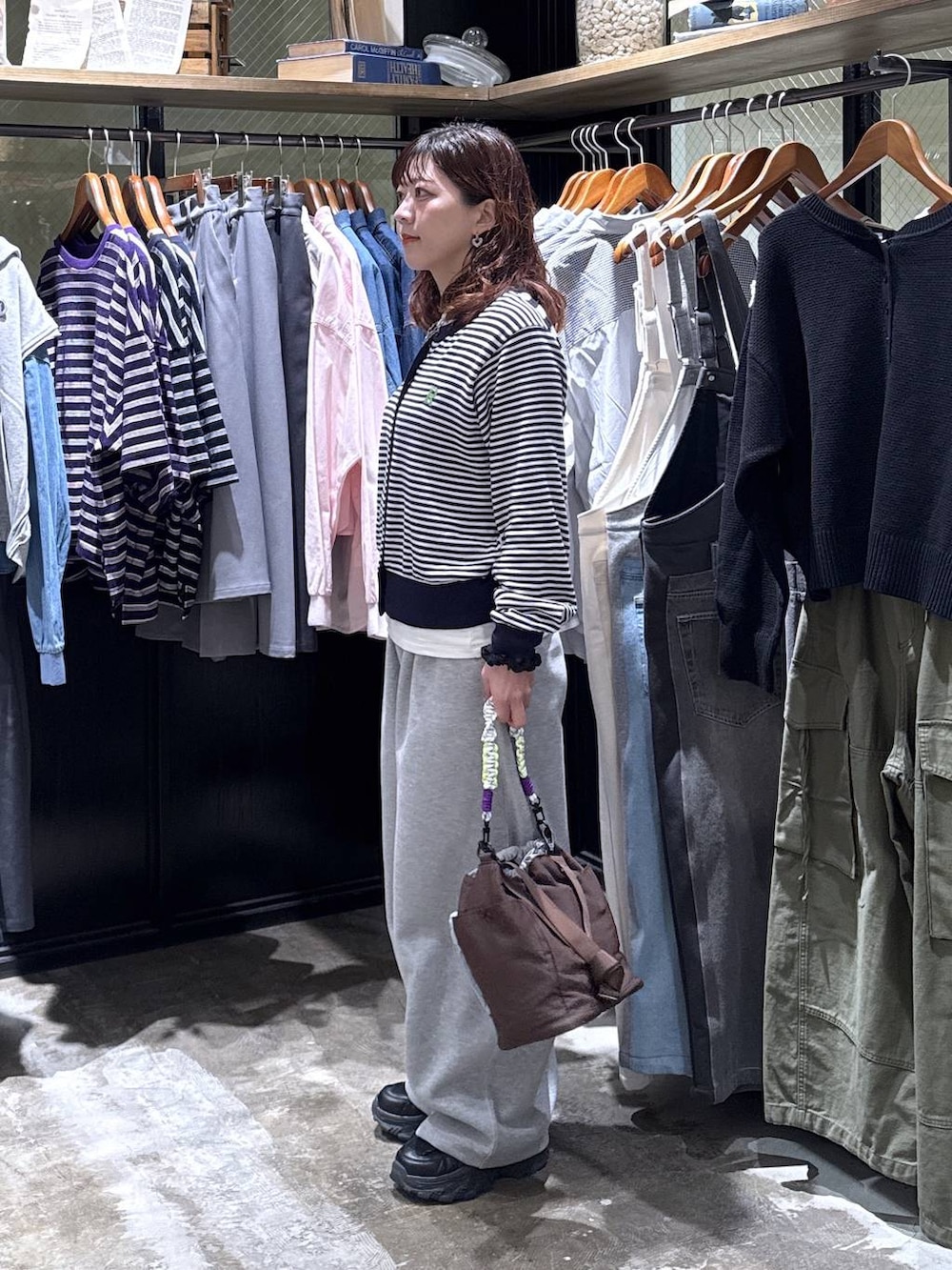 ブラック系のスニーカー、グレー系のスウェットパンツ、その他のショルダーバッグを着用したレディースの冬コーディネートの3枚目の写真