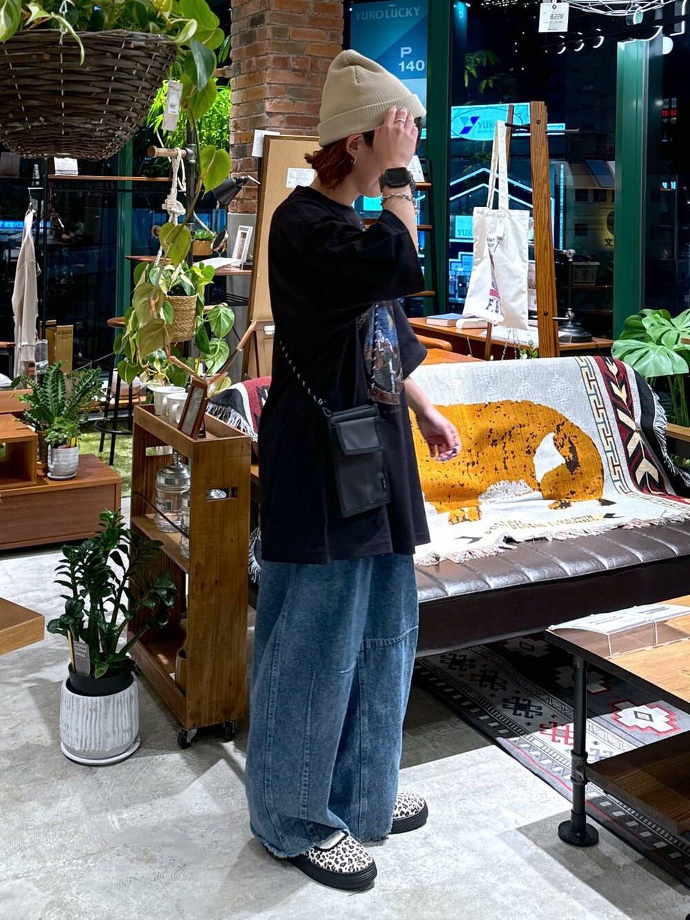 ブラック系のショルダーバッグ、ブルー系のデニムパンツ、ブラック系のTシャツ/カットソーを着用したレディースの夏コーディネートの6枚目の写真