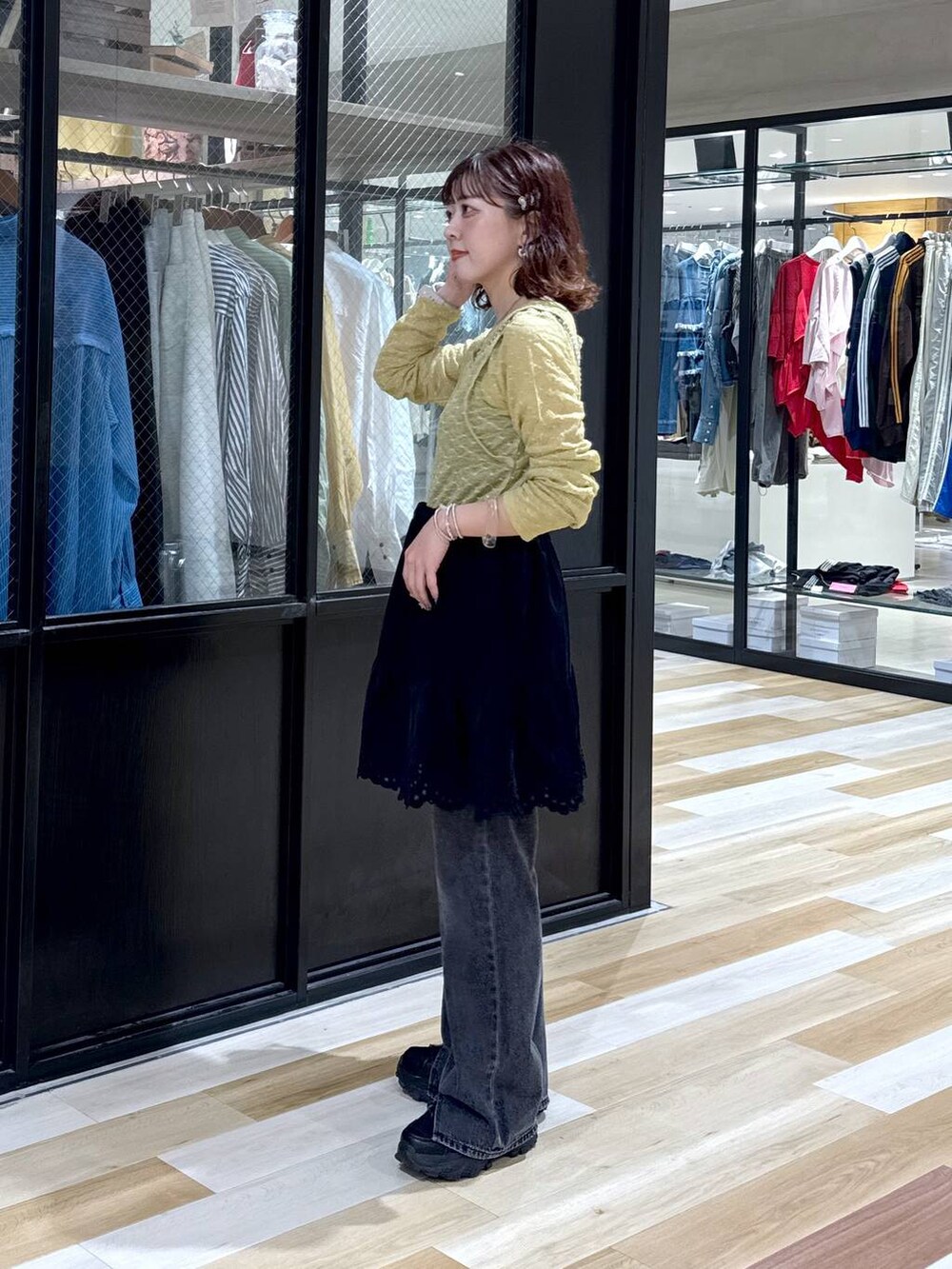 シルバー系のショルダーバッグ、グレー系のデニムパンツ、ブラック系のスニーカーを着用したレディースの夏コーディネートの4枚目の写真