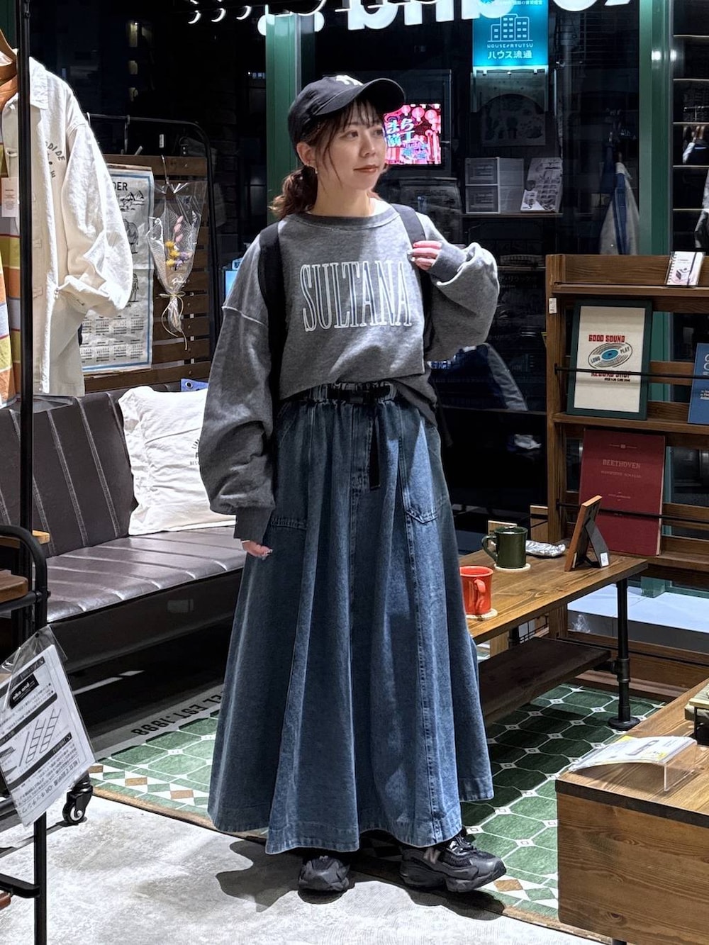 ブルー系のスカート、グレー系のTシャツ/カットソー、ブラック系のバックパック/リュックを着用したレディースの春コーディネートの2枚目の写真