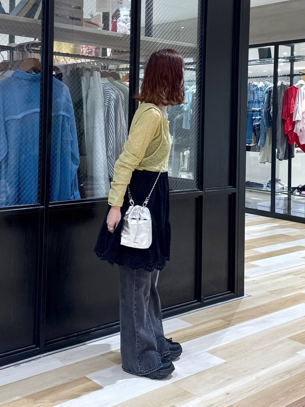 シルバー系のショルダーバッグ、グレー系のデニムパンツ、ブラック系のスニーカーを着用したレディースの夏コーディネートの7枚目の写真