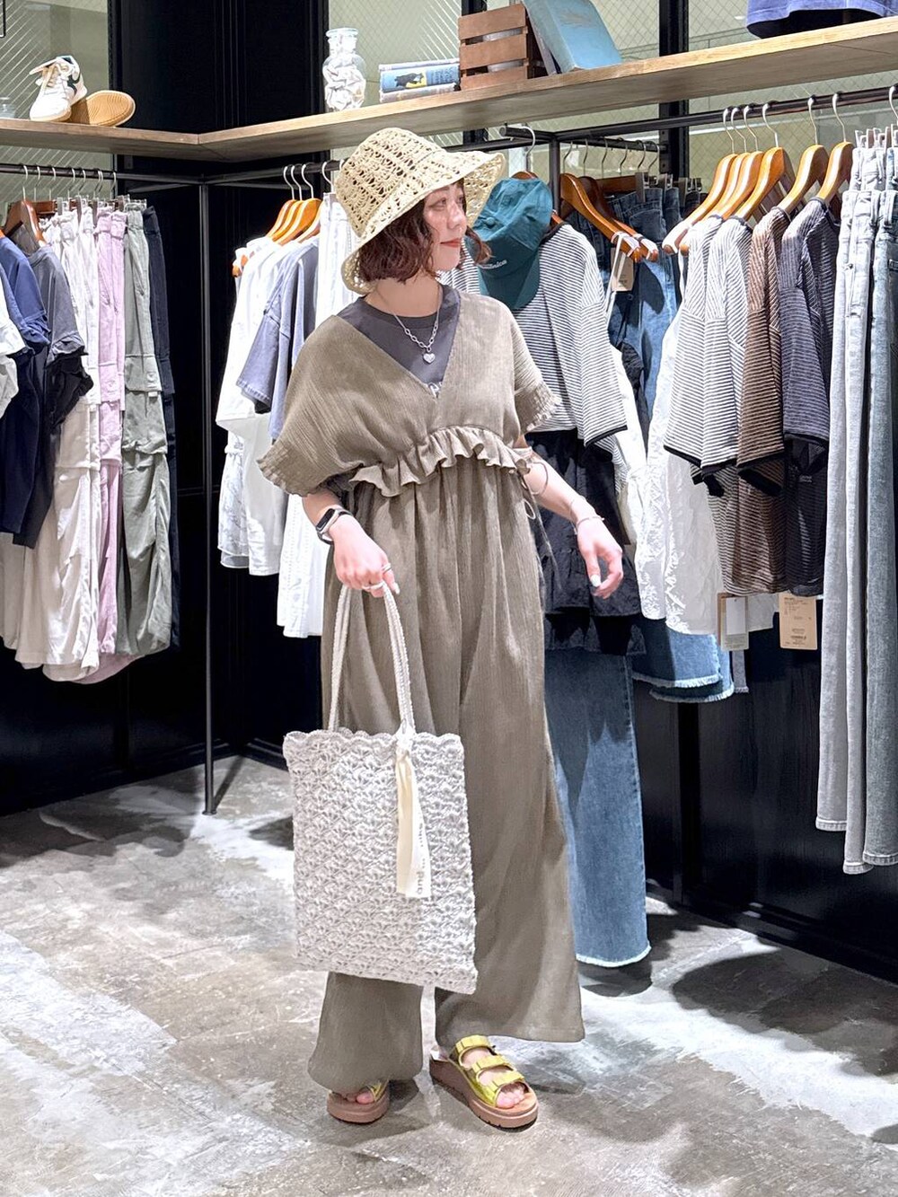 イエロー系のサンダル、シルバー系のトートバッグ、グリーン系のサロペット/オーバーオールを着用したレディースの春コーディネートの2枚目の写真