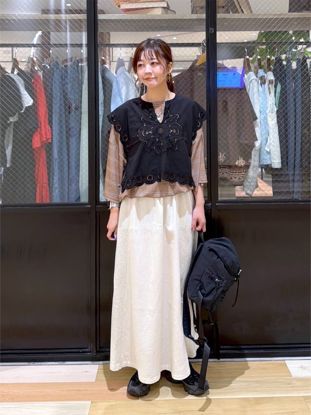 ブラック系のベスト、ブラウン系のTシャツ/カットソー、ブラック系のバックパック/リュックを着用したレディースの夏コーディネートの7枚目の写真
