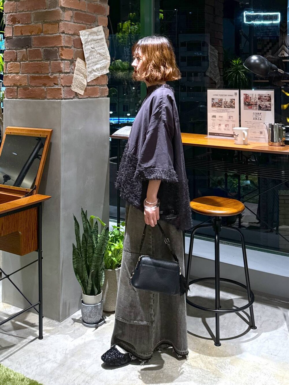 ブラック系のバレエシューズ、ブラック系のショルダーバッグ、ブラウン系のデニムパンツを着用したレディースの秋コーディネートの5枚目の写真