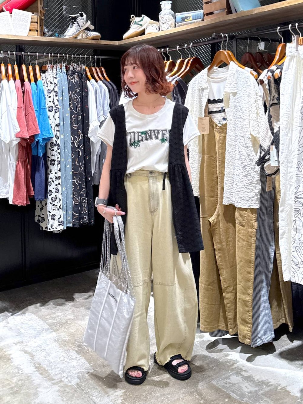 ベージュ系のその他パンツ、ブラック系のベスト、ブラック系のサンダルを着用したレディースの夏コーディネートの2枚目の写真