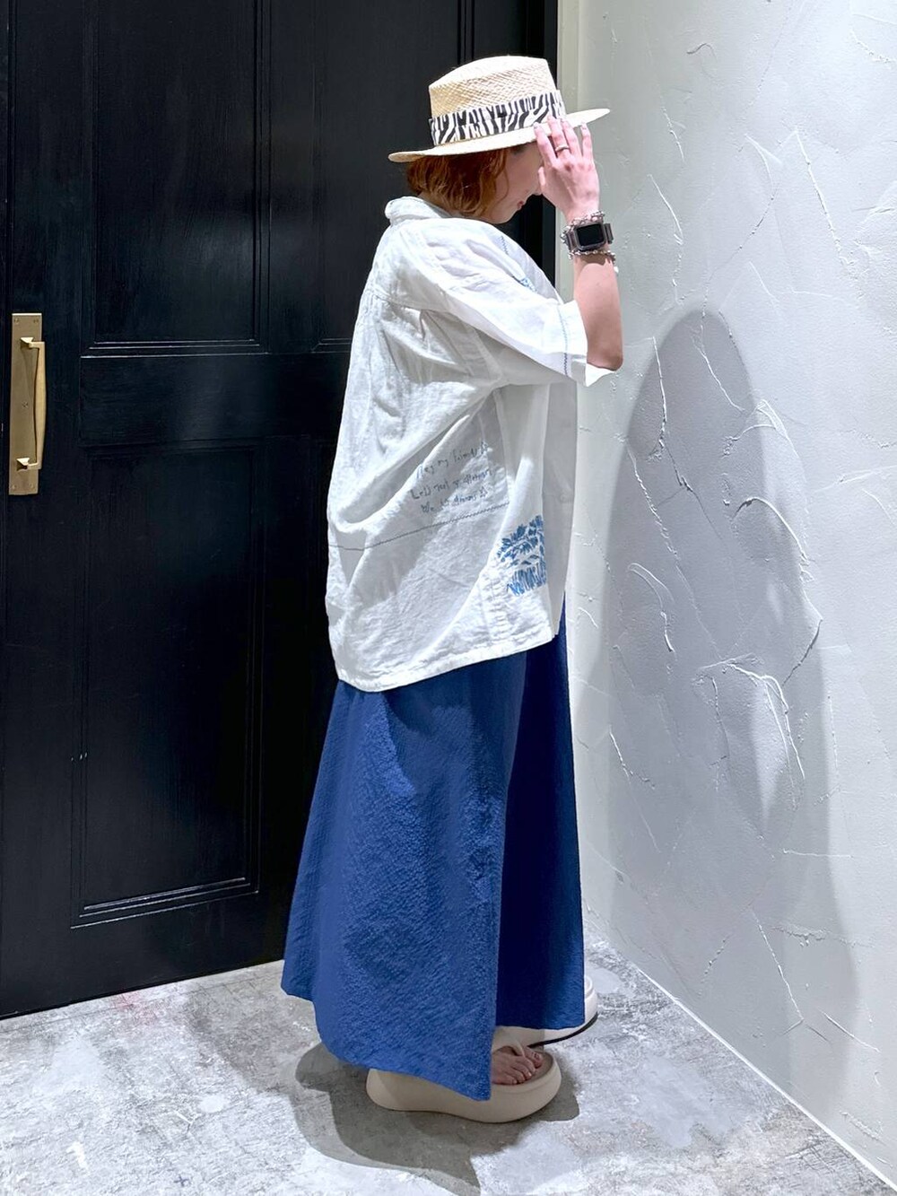 グレー系のショルダーバッグ、ベージュ系のサンダル、ブルー系のジャンパースカートを着用したレディースの夏コーディネートの7枚目の写真