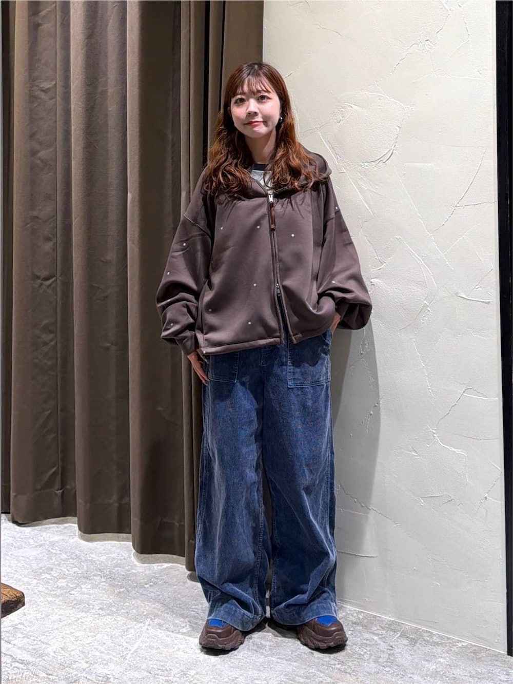 ブラウン系のパーカー、グレー系のTシャツ/カットソー、ブラウン系のスニーカーを着用したレディースの秋コーディネートの2枚目の写真