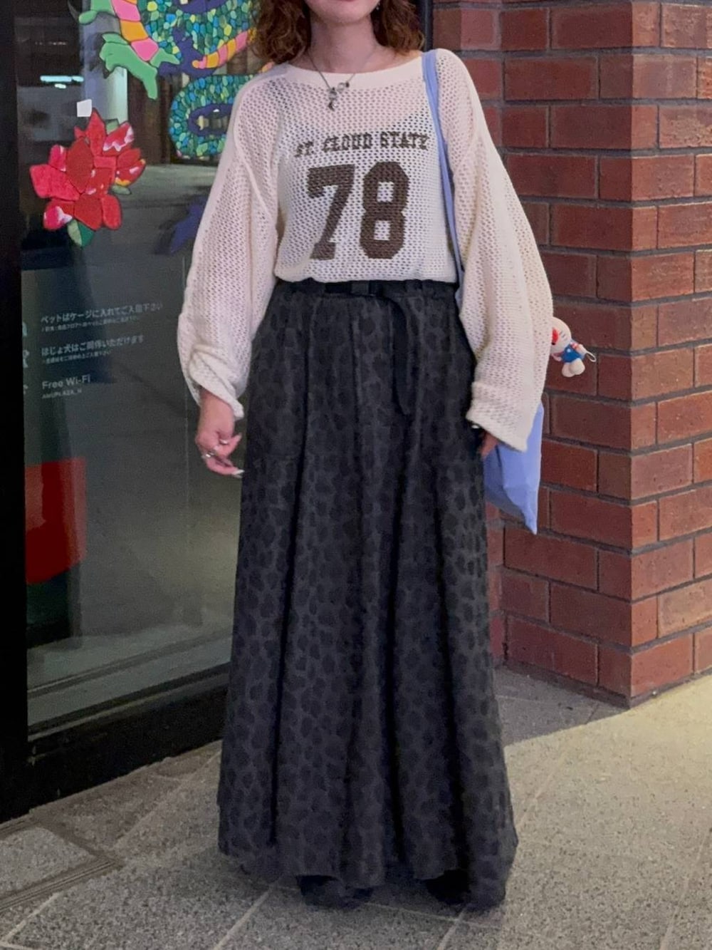 グレー系のスカート、ブラック系のスニーカー、ベージュ系のTシャツ/カットソーを着用したレディースの秋コーディネートの4枚目の写真