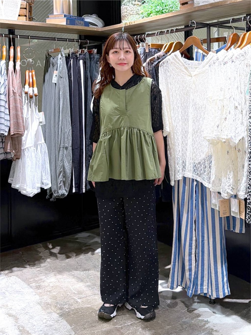 グレー系のその他パンツ、グリーン系のベストを着用したレディースの夏コーディネートの2枚目の写真