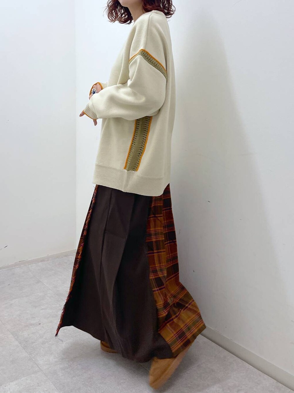 オレンジ系のスカート、ベージュ系のニット/セーター、イエロー系のその他シューズを着用したレディースの冬コーディネートの3枚目の写真