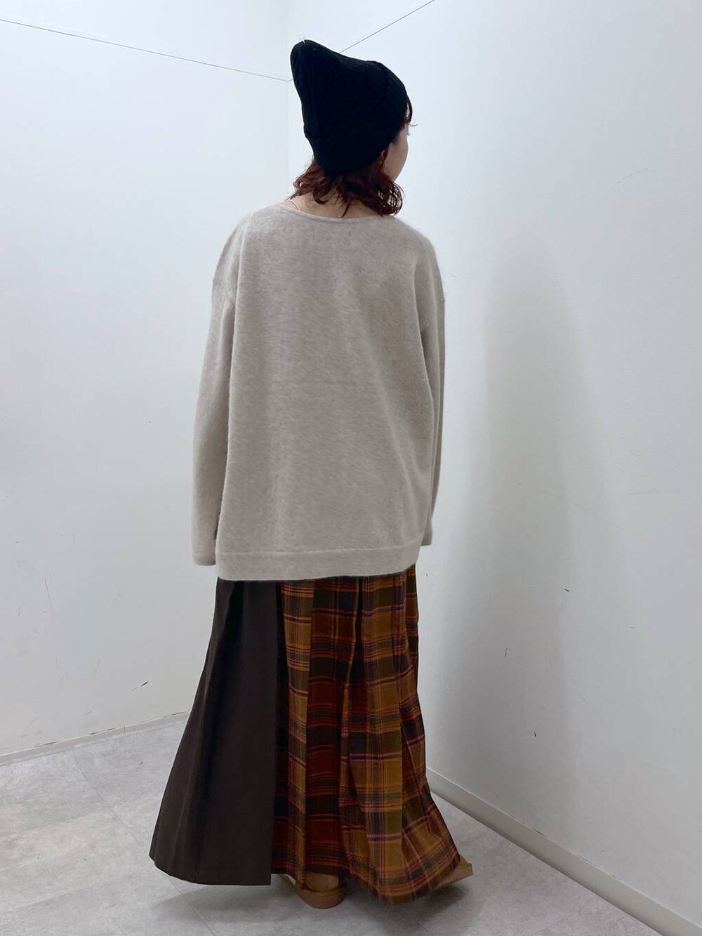 オレンジ系のスカート、ベージュ系のニット/セーター、イエロー系のその他シューズを着用したレディースの冬コーディネートの8枚目の写真