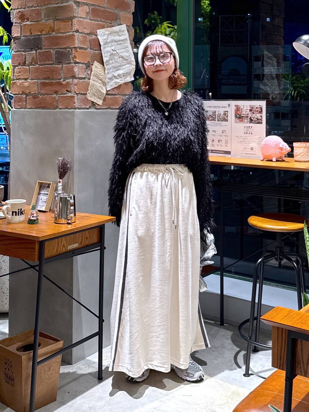 シルバー系のショルダーバッグ、ブラック系のその他トップス、ベージュ系のスカートを着用したレディースの冬コーディネートの6枚目の写真