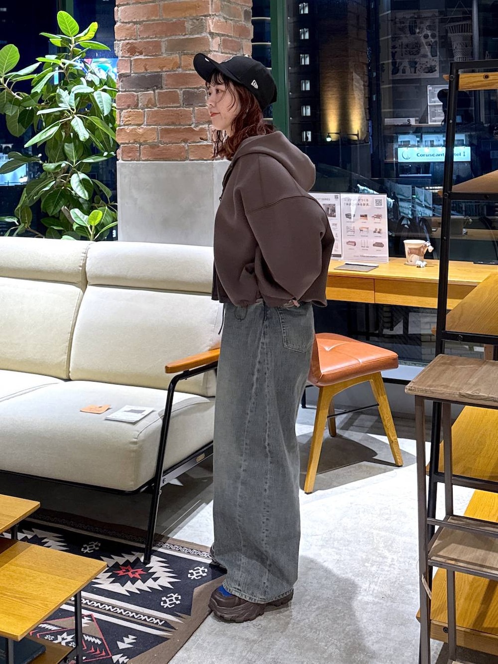 ブラウン系のスニーカー、ブルー系のデニムパンツ、ブラウン系のパーカーを着用したレディースの冬コーディネートの4枚目の写真