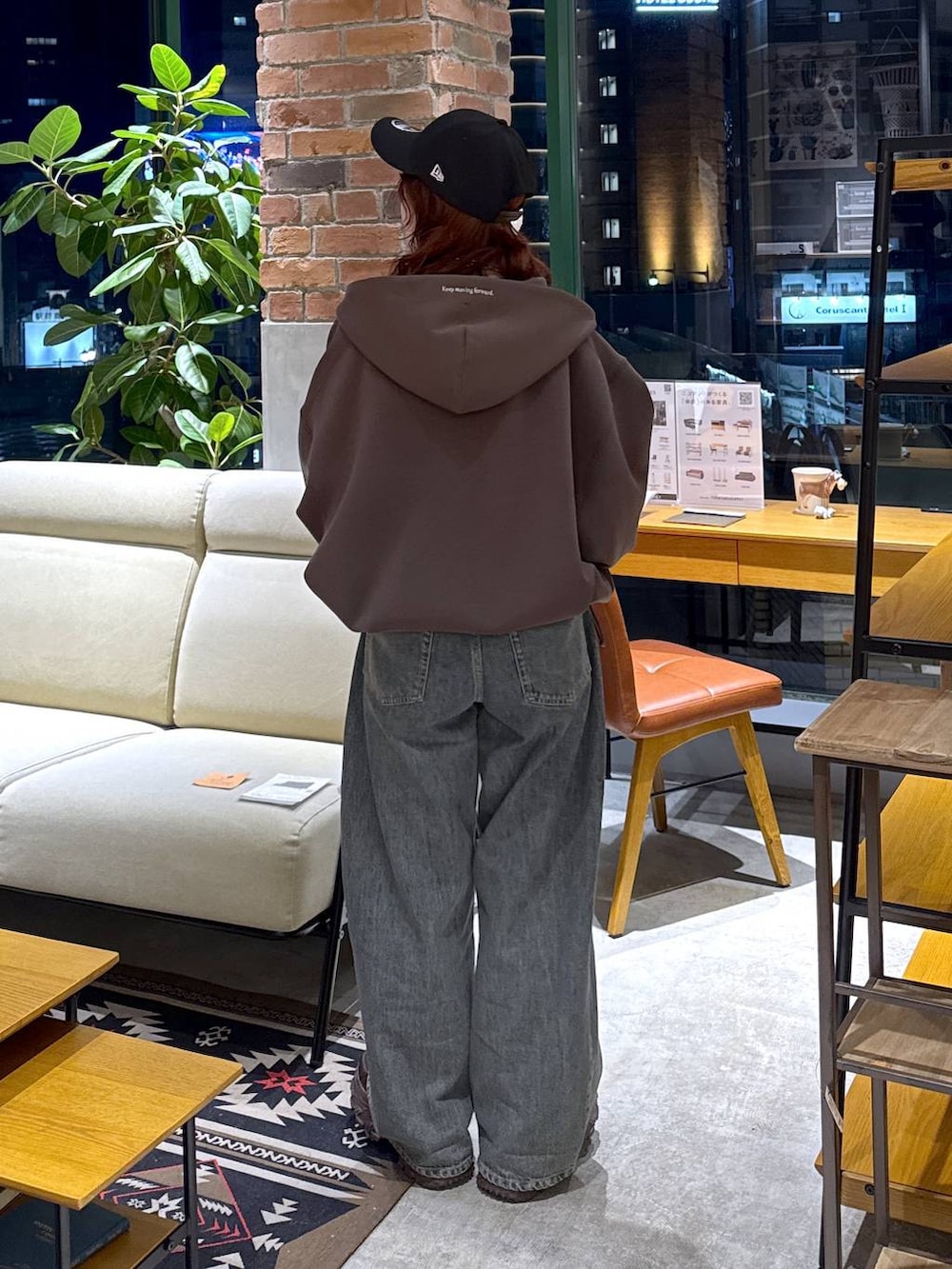 ブラウン系のスニーカー、ブルー系のデニムパンツ、ブラウン系のパーカーを着用したレディースの冬コーディネートの5枚目の写真