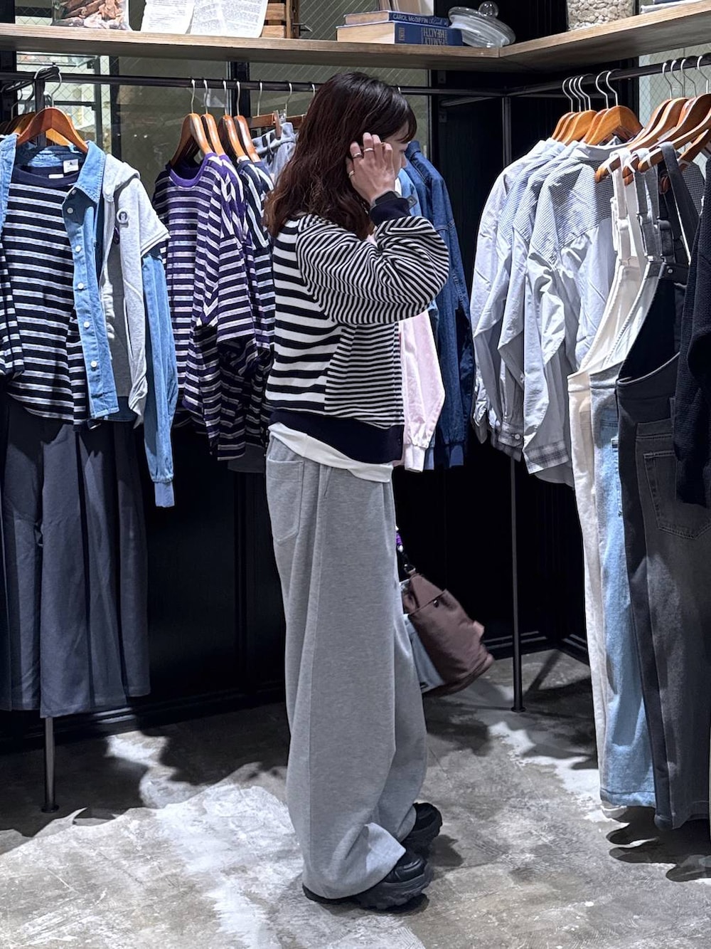 ブラック系のスニーカー、グレー系のスウェットパンツ、その他のショルダーバッグを着用したレディースの冬コーディネートの5枚目の写真