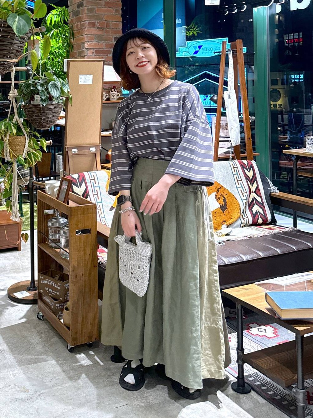 グレー系のショルダーバッグ、ブラック系のサンダル、グレー系のTシャツ/カットソーを着用したレディースの春コーディネートの3枚目の写真