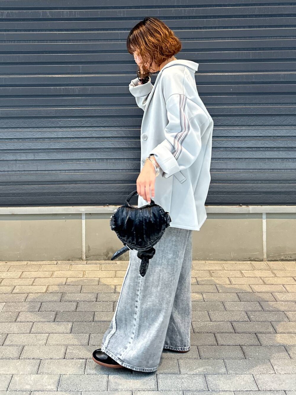 グレー系のデニムパンツ、グレー系のテーラードジャケット、ブラック系のスニーカーを着用したレディースの夏コーディネートの3枚目の写真