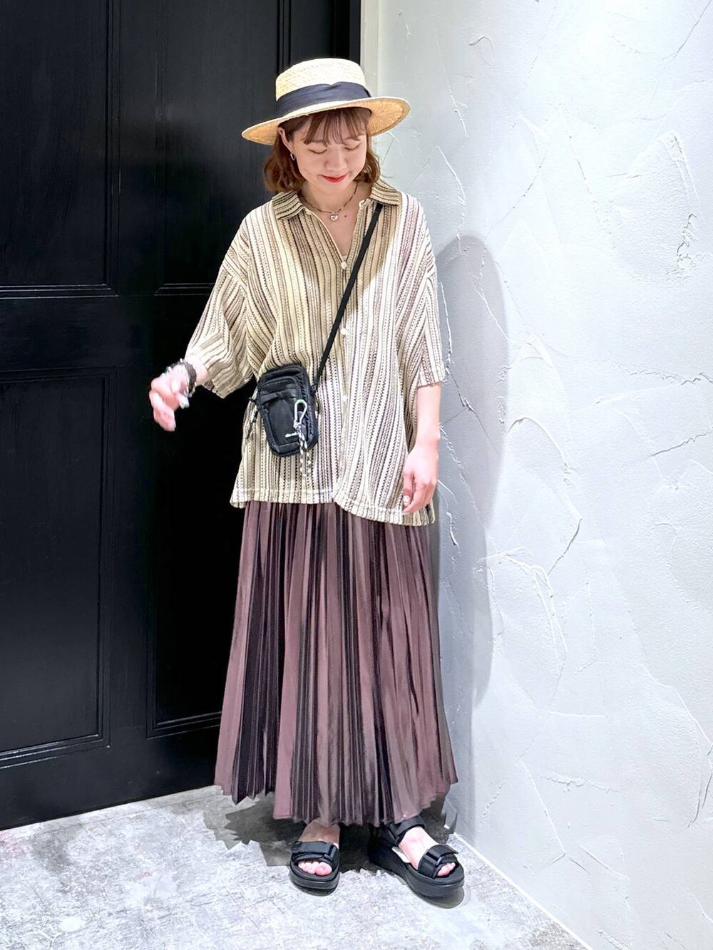 ブラック系のサンダル、ベージュ系のスカート、ブラック系のショルダーバッグを着用したレディースの夏コーディネートの3枚目の写真