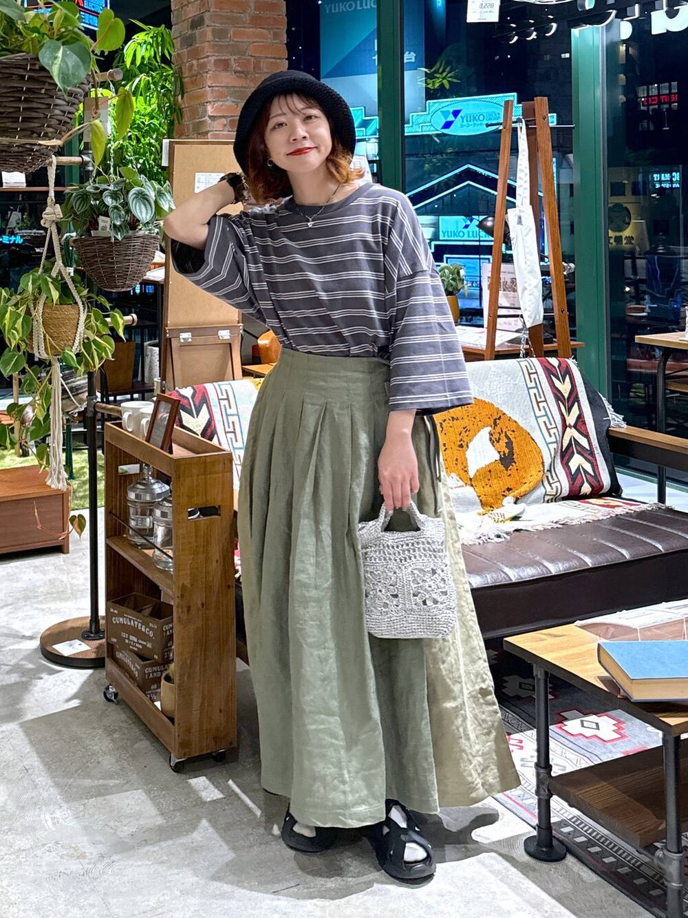 グレー系のショルダーバッグ、ブラック系のサンダル、グレー系のTシャツ/カットソーを着用したレディースの春コーディネートの4枚目の写真