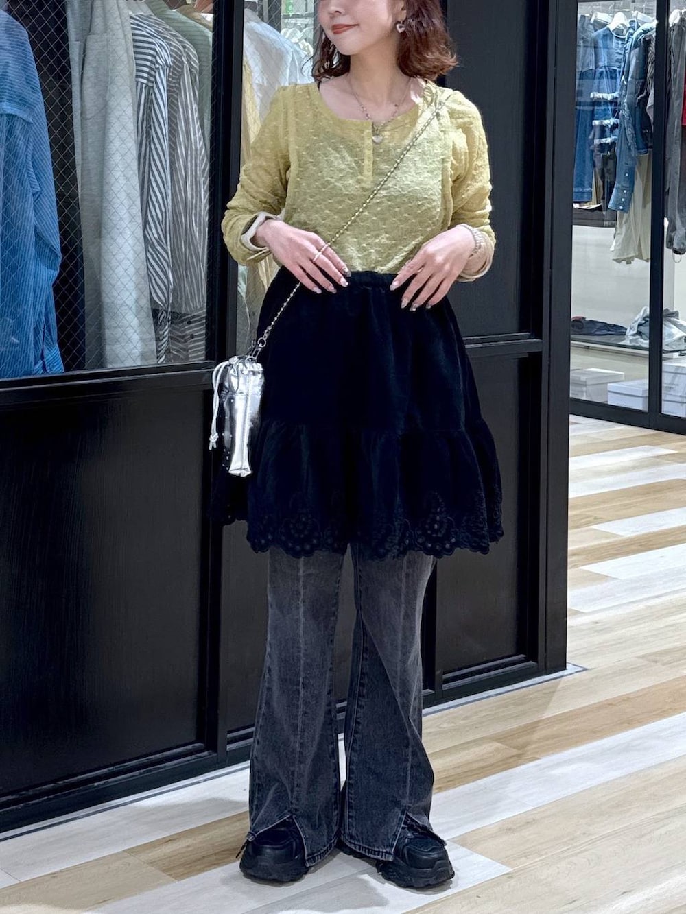 シルバー系のショルダーバッグ、グレー系のデニムパンツ、ブラック系のスニーカーを着用したレディースの夏コーディネートの9枚目の写真