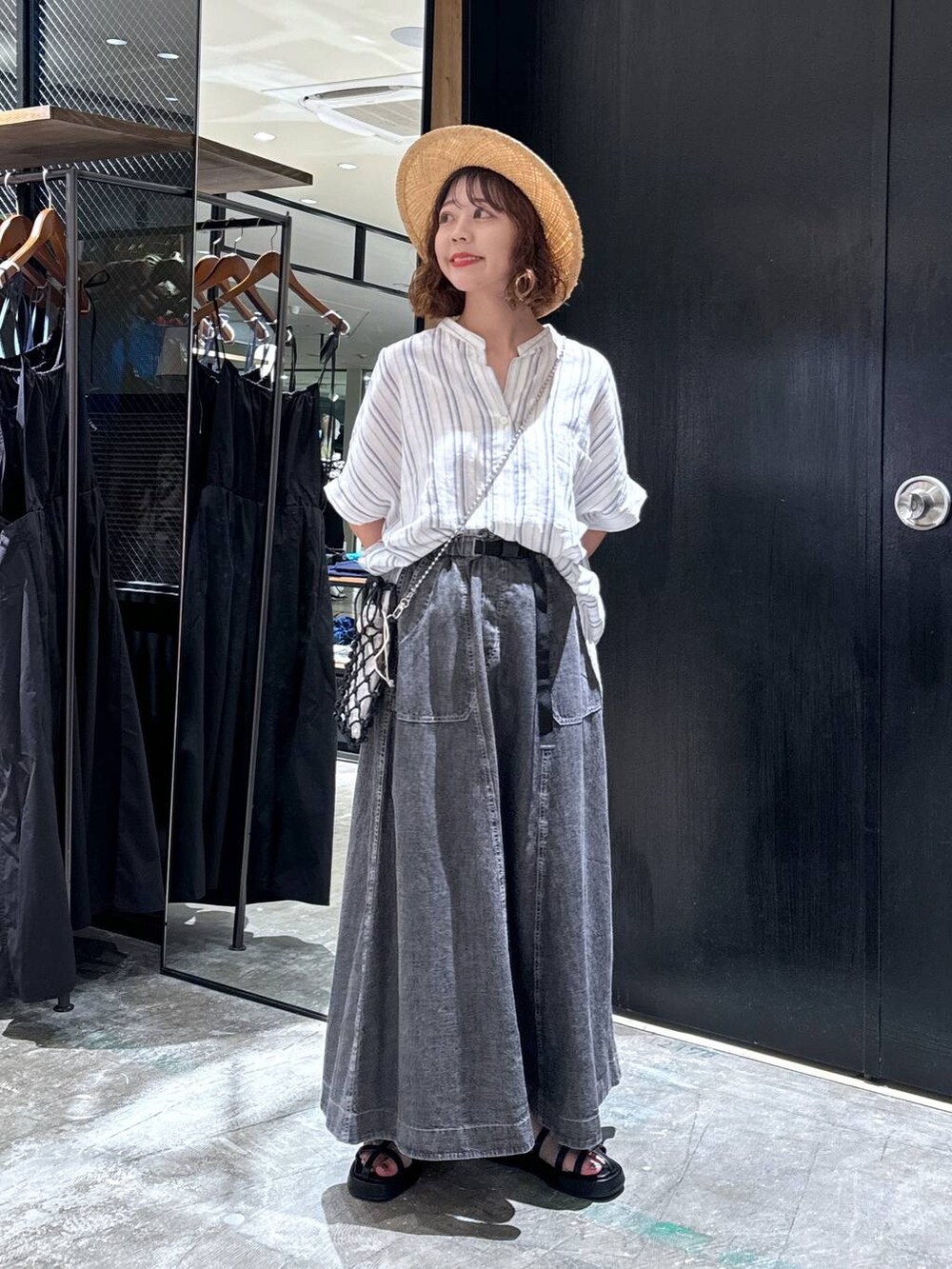 ブラック系のショルダーバッグ、ブラック系のサンダル、ベージュ系のシャツ/ブラウスを着用したレディースの夏コーディネートの5枚目の写真