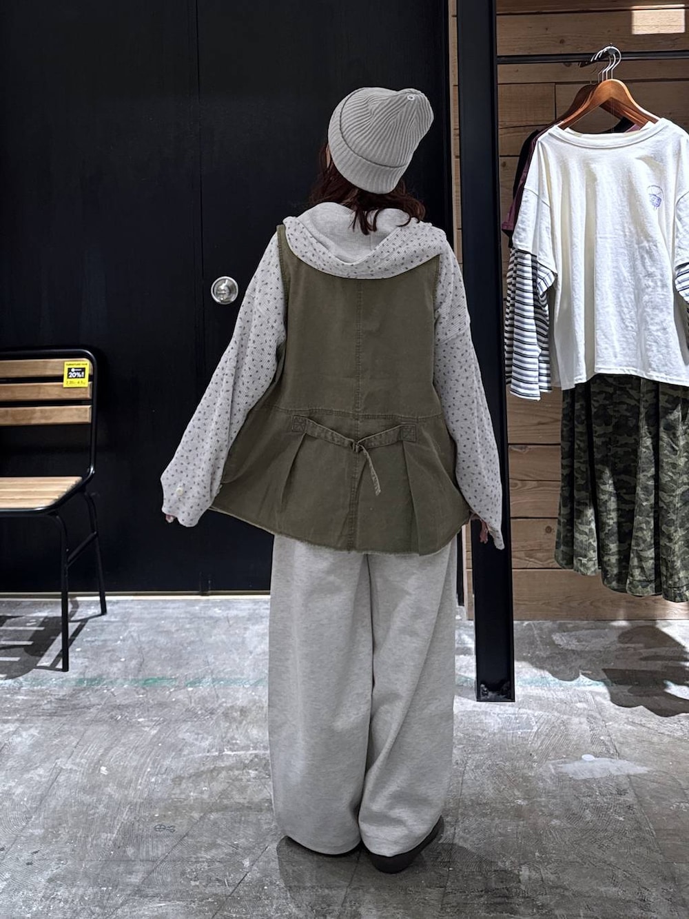 グリーン系のベスト、ベージュ系のパーカー、ブラウン系のローファーを着用したレディースの冬コーディネートの4枚目の写真