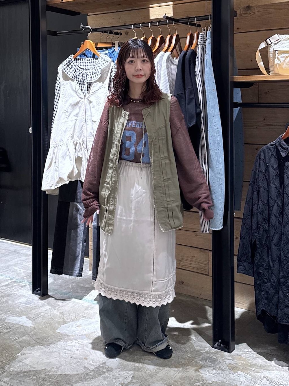 グリーン系のベスト、ブルー系のデニムパンツ、ベージュ系のTシャツ/カットソーを着用したレディースの春コーディネートの8枚目の写真