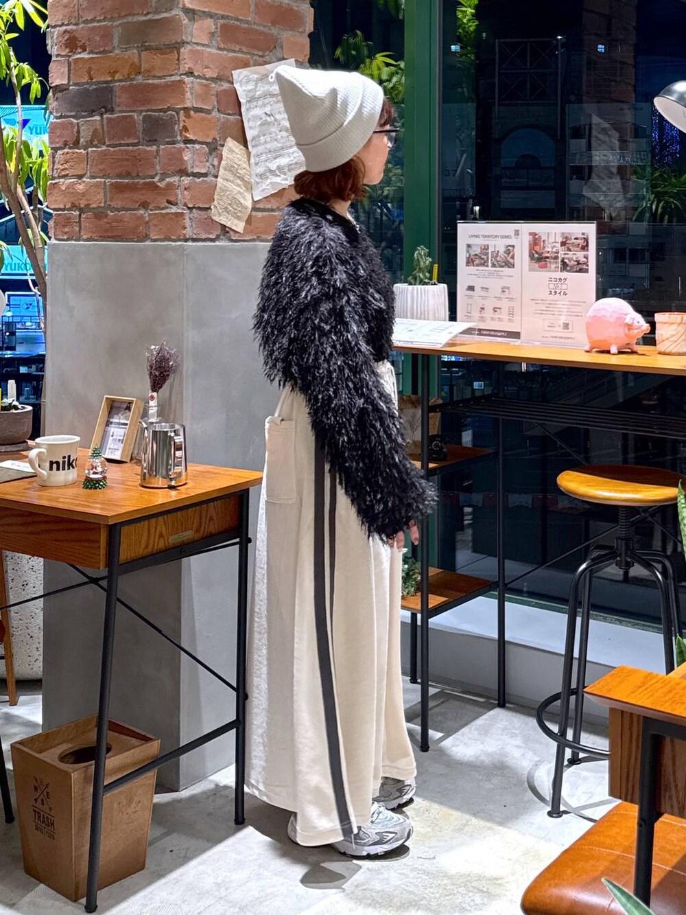 シルバー系のショルダーバッグ、ブラック系のその他トップス、ベージュ系のスカートを着用したレディースの冬コーディネートの3枚目の写真