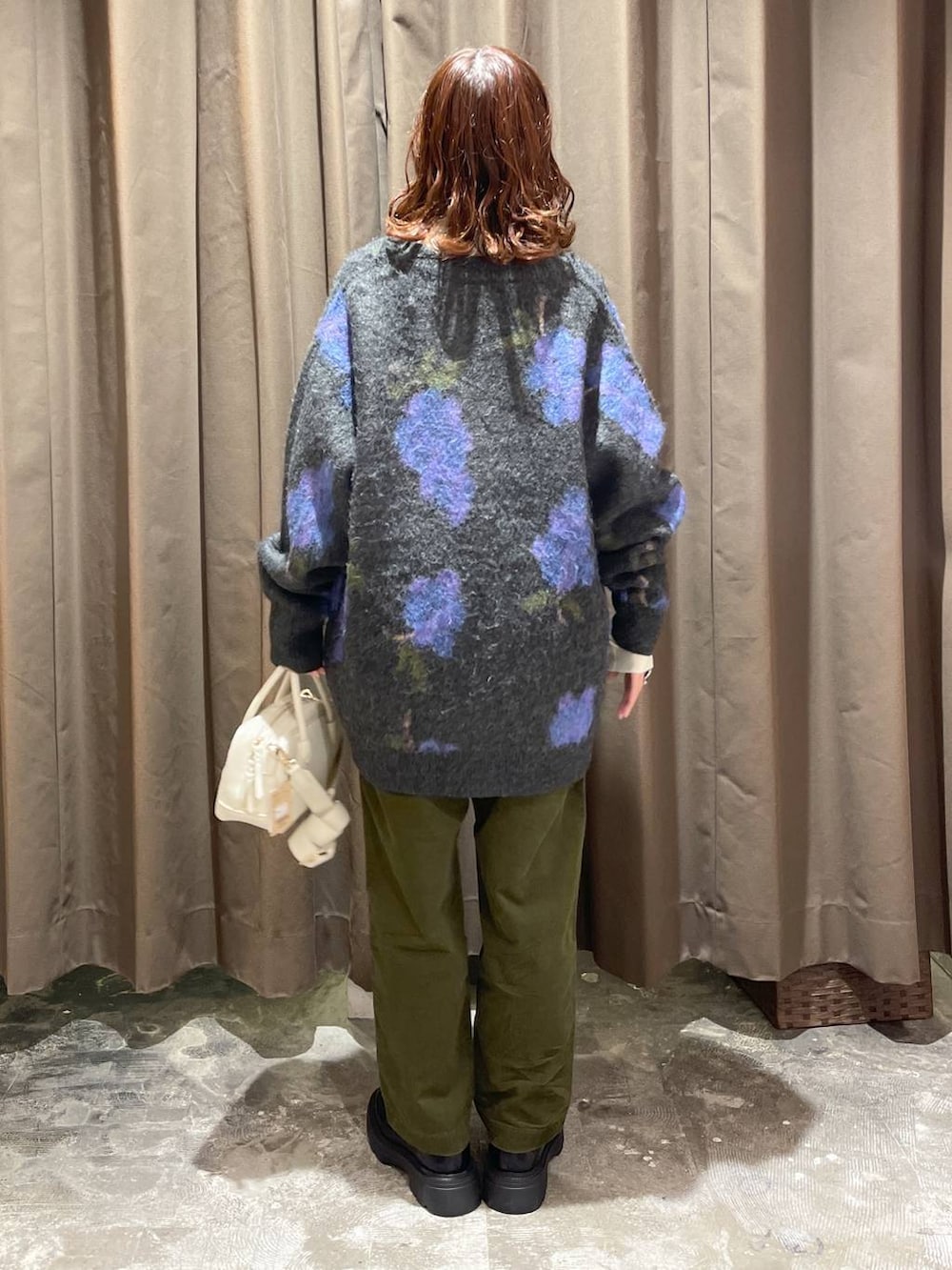 ベージュ系のニット/セーター、ブラック系のローファー、ベージュ系のショルダーバッグを着用したレディースの冬コーディネートの4枚目の写真